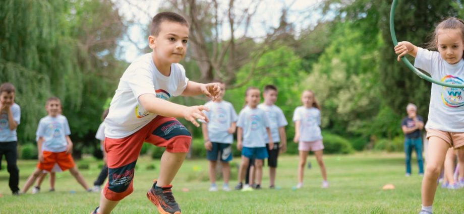 A group of children actively playing with hula hoops on a bright summer day in the park.